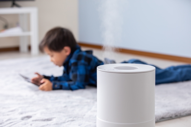 リビングに寝そべる子供と加湿器